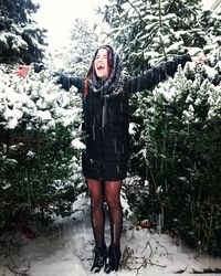 Portrait of smiling young woman standing in snow