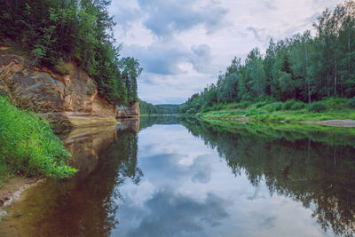 Scenic view of lake by trees against sky