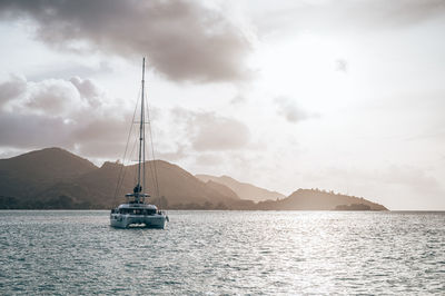 Sailboat sailing on sea against sky