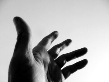 Close-up of cropped hand against white background