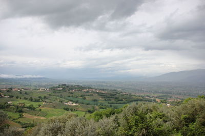 Scenic view of green landscape against cloudy sky