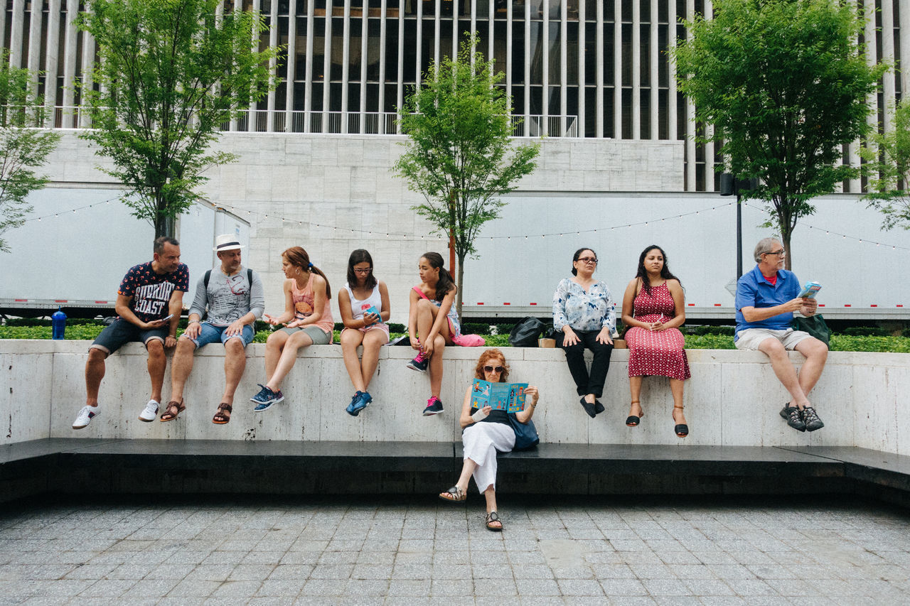 full length, medium group of people, outdoors, day, building exterior, real people, architecture, built structure, friendship, togetherness, sitting, city, tree, young adult, people, adult