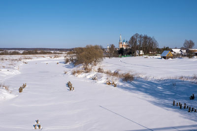 People on snow covered land against sky