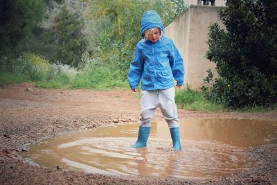 Full length of child standing in puddle