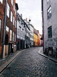 Footpath amidst buildings in city