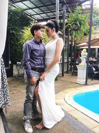 Young couple standing by poolside