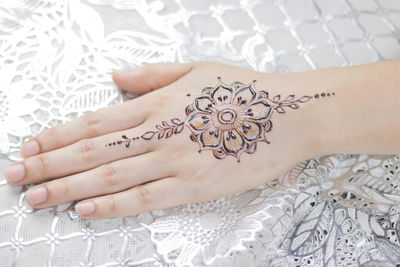 High angle view of woman hand with tattoo