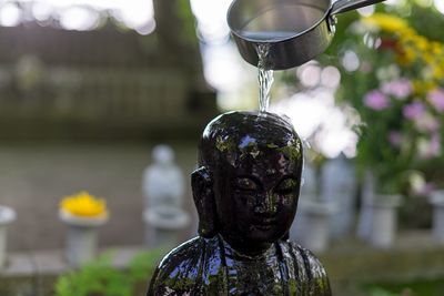 Close-up of water falling on statue in garden