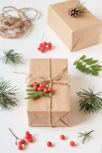 Christmas gift, packed in kraft paper and decorated with a bunch of mountain ash