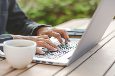 Midsection of woman using mobile phone on table