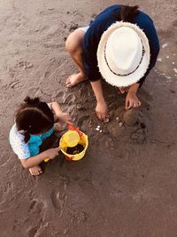 High angle view of mother and daughter playing at beach