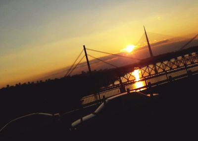 Silhouette bridge against sky during sunset