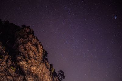 Low angle view of rock against sky at night