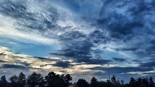 Silhouette of trees against cloudy sky