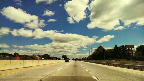 Empty road against cloudy sky