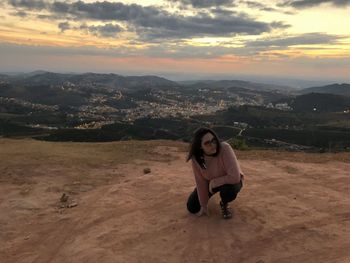 Full length portrait of woman against sky during sunset