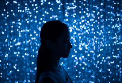 Close-up of illuminated lighting equipment against gray background