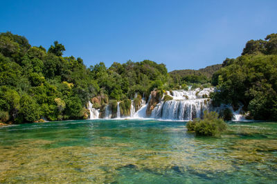 Scenic view of waterfall against clear sky