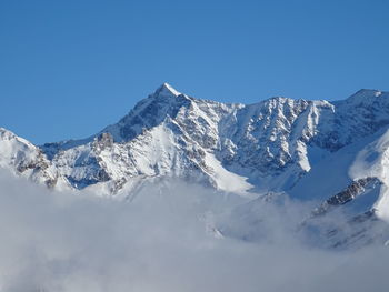 Scenic view of snowcapped mountains against clear blue sky