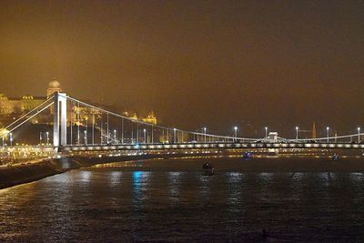 Suspension bridge over river at night