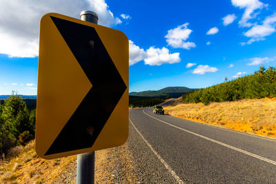 Road sign against sky