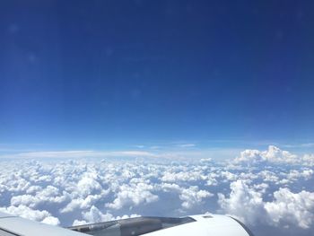 Low angle view of airplane wing over landscape