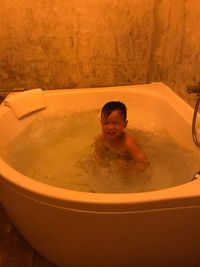 Boy taking bath in tub at home