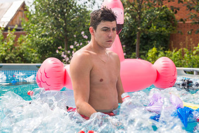 Portrait of shirtless man in swimming pool
