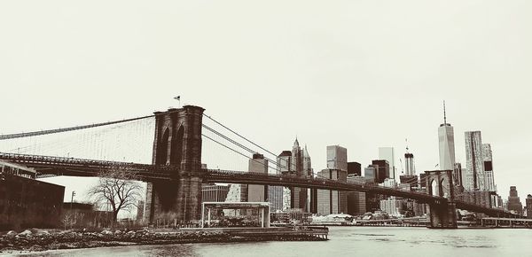 View of bridge and cityscape against clear sky