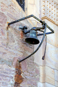 Low angle view of electric lamp hanging on wall