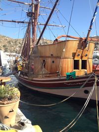 Sailboats moored at harbor against sky