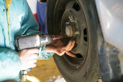 Midsection of man repairing car