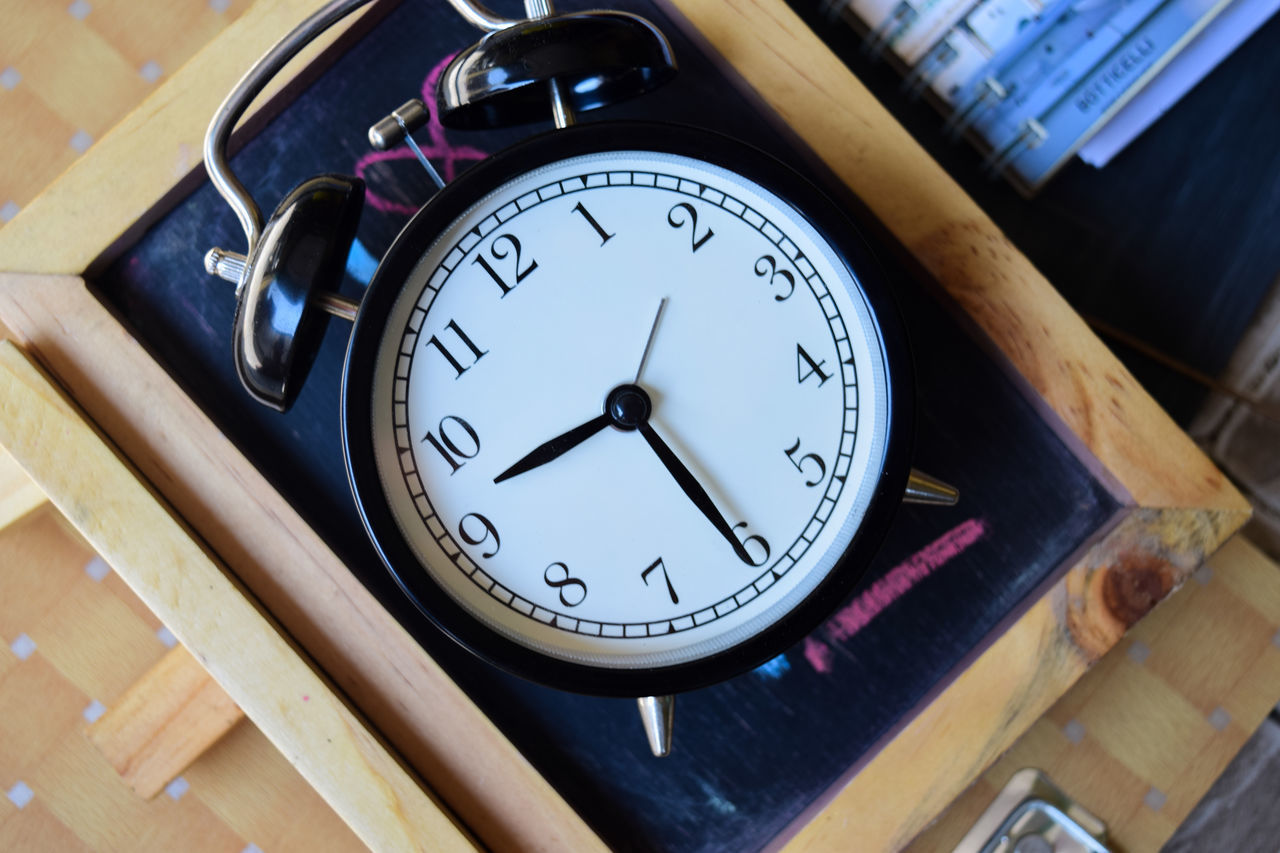 HIGH ANGLE VIEW OF CLOCK ON TABLE IN MIRROR