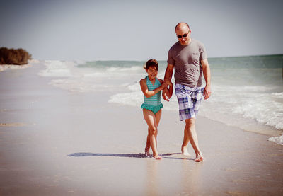 Full length of father and son on beach
