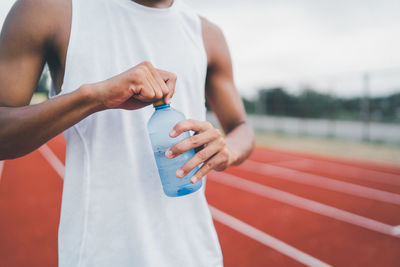 Midsection of woman holding bottle