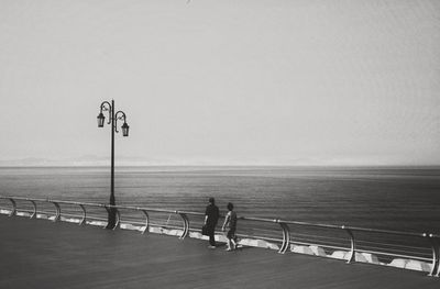 Man standing by sea against clear sky