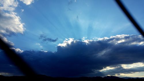 Low angle view of mountain range against cloudy sky