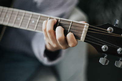 Midsection of man playing guitar