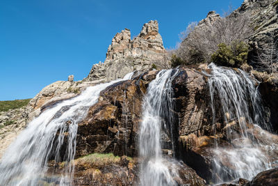 Low angle view of waterfall against sky