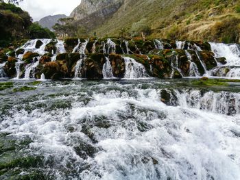 Scenic view of waterfall against sky