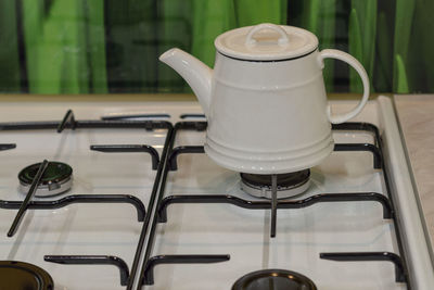 Close-up of wine metal teapot  on gas plate  at home