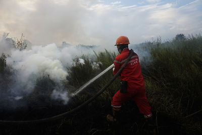 Rear view of firefighter working on field