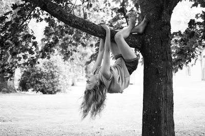 Full length of girl hanging on tree