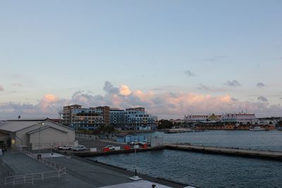 Cityscape by sea against sky