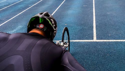 Rear view of man riding bicycle on road