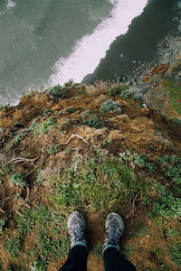 Low section of person standing in water