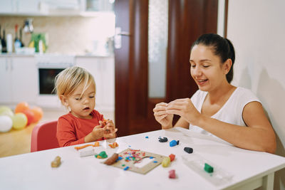 Mother playing with toy blocks at home