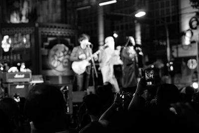 Group of people photographing at night