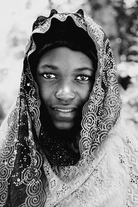 Portrait of young woman standing against blurred background