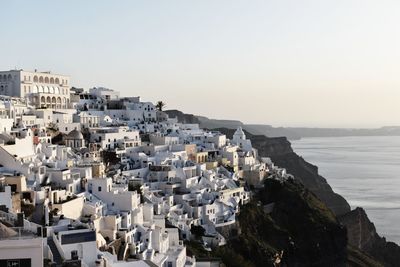 Aerial view of townscape by sea against clear sky